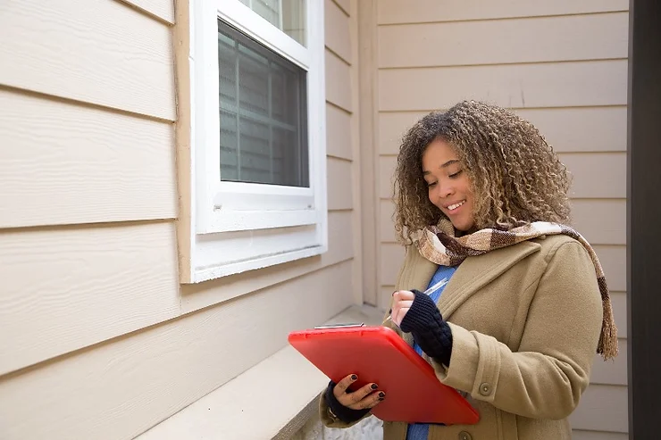 an appraiser taking notes outside a home