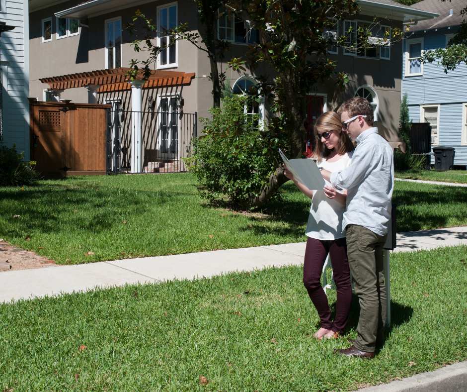 a couple looking at homes outside