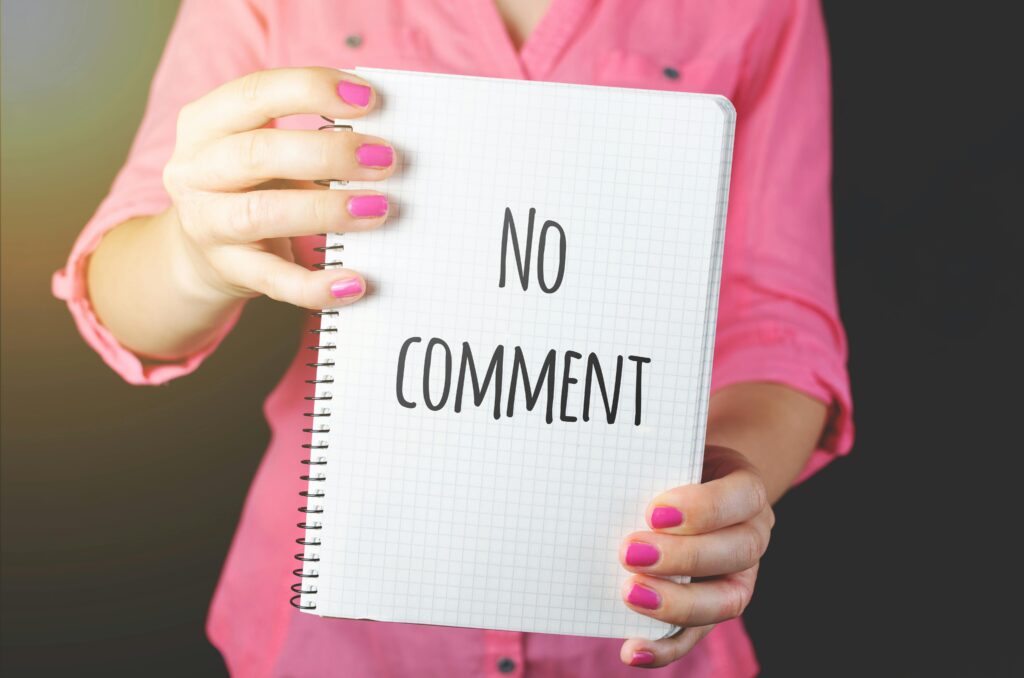 woman holding "no comment" sign